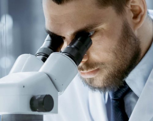 guy looking through microscope